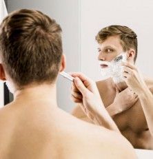 Hombre afeitándose frente al espejo
