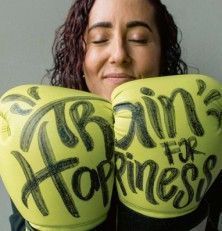 mujer con guantes de boxeo amarillos con letras