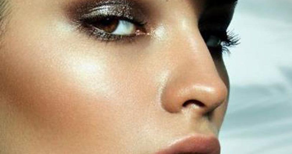 Rostro femenino de perfil mirando a cámara muy maquillado