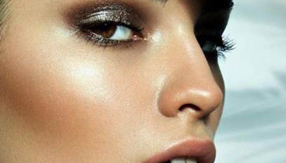 Rostro femenino de perfil mirando a cámara muy maquillado