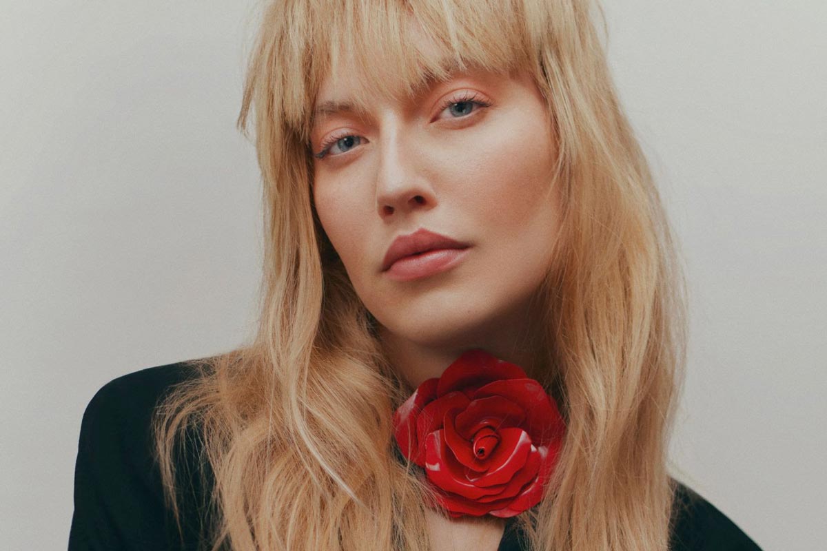 chica rubia flequillo flor en el cuello