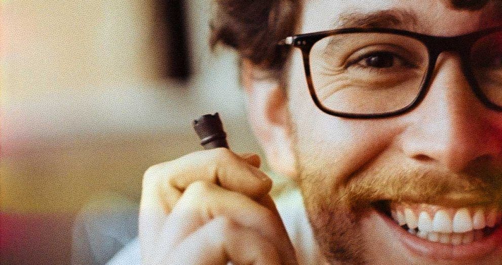 chico sonriente con una pieza de ajedrez en la mano