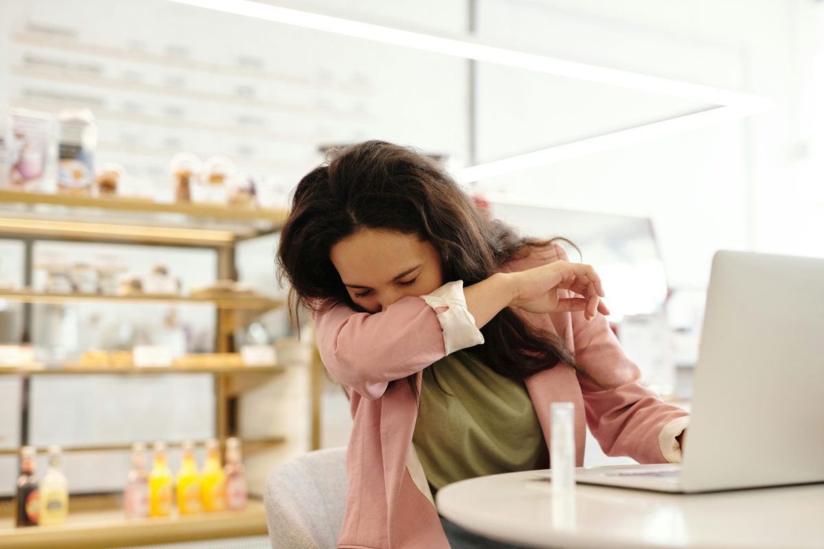 chica tosiendo en su codo
