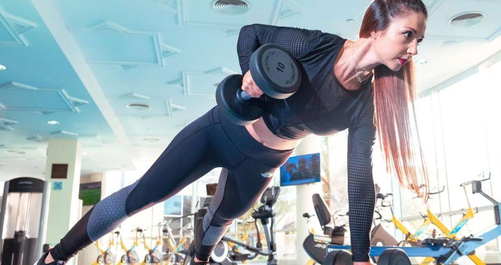 chica flexiones de brazos con pesas