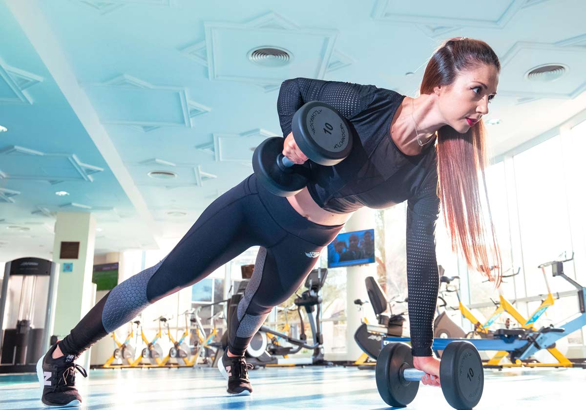 chica flexiones de brazos con pesas
