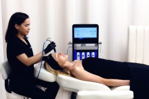 Terapeuta haciendo tratamiento facial con péptidos a chica en camilla