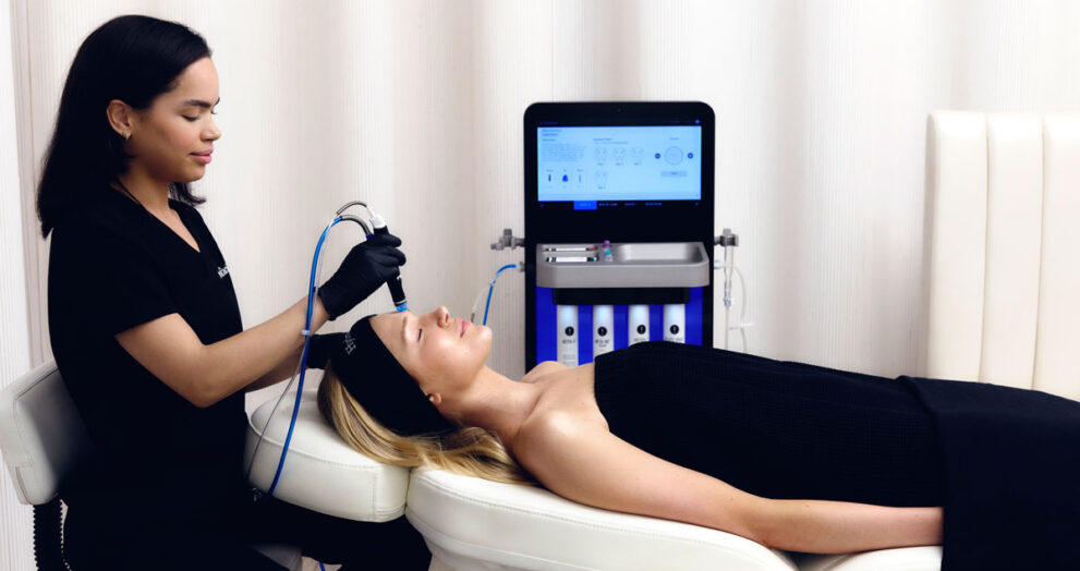 Terapeuta haciendo tratamiento facial con péptidos a chica en camilla
