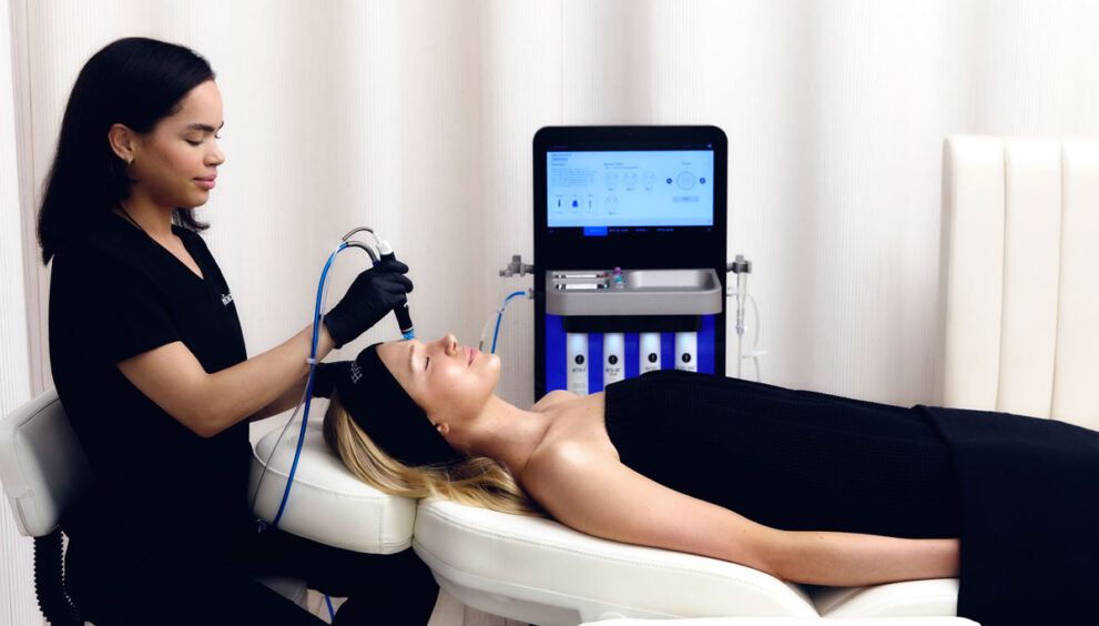 Terapeuta haciendo tratamiento facial con péptidos a chica en camilla